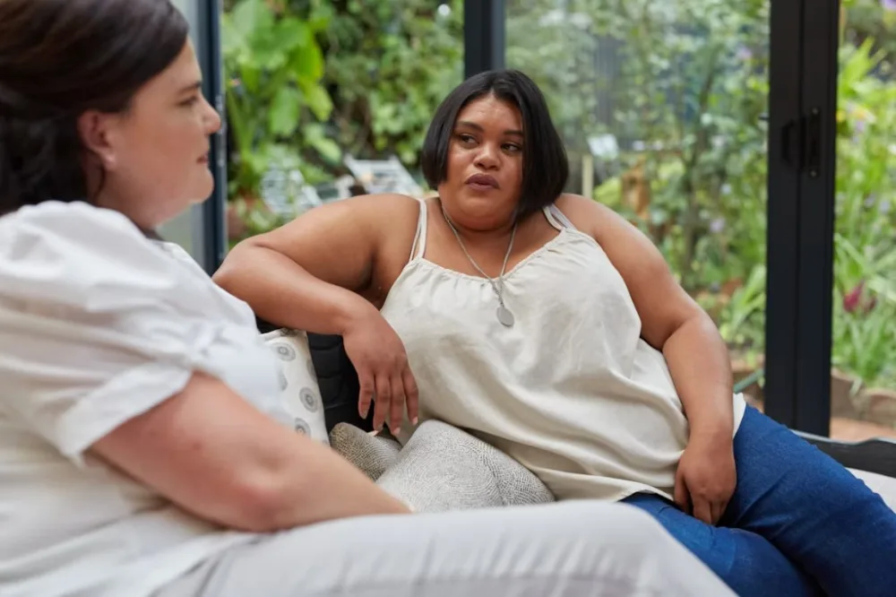 Two women connecting in a warm coaching conversation